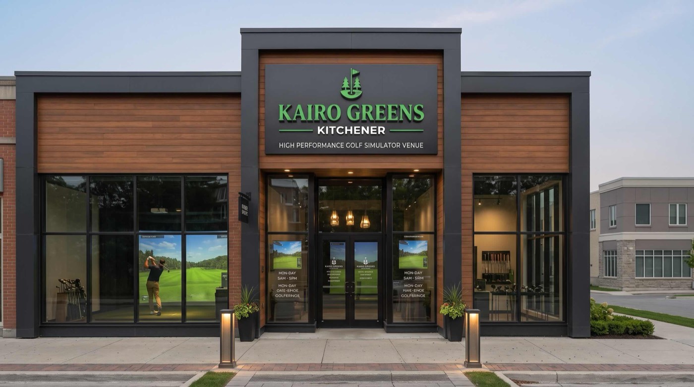 The lit Kairo Greens Kitchener storefront at dusk, a golfer mid-swing visible in a bay through the front window